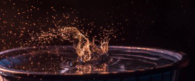 Karanlık sisli arka planda su sıçraması. Seçici odak.