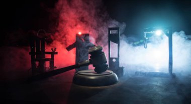 Hukuk hukuku ya da suç ve infaz kavramı. Ölüm cezası minyatürleri masada. Geceleri yalnız başına idamını bekleyen bir adam. Kelepçeli sanat dekorasyonu, Adalet Heykeli ve adalet tokmağı.