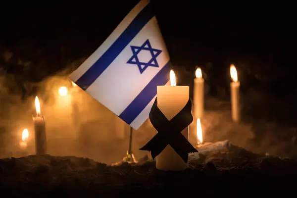 stock image Israel flag on burning dark background with candle. Attack on Israel, mourning for victims concept or Concept of crisis of war and political conflict. Selective focus