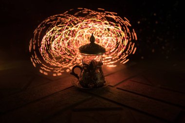 Arap çayı bardakta, doğu aperatifleriyle birlikte koyu arkaplanda, ışık ve dumanlı taş bir zemin üzerinde. Doğu çay konsepti. Seçici odak.