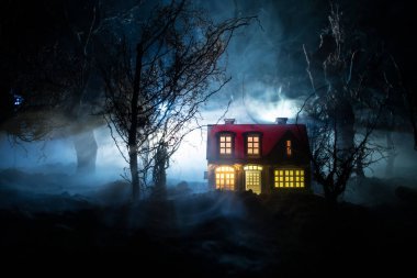 Karanlık ormanda ışıkla duran bir insan silueti. Korku Cadılar Bayramı konsepti. Karanlık ve ürkütücü bir köyde tuhaf bir siluet.