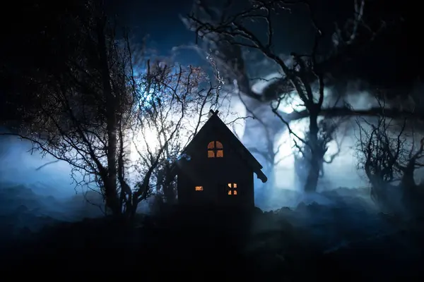 Karanlık ormanda ışıkla duran bir insan silueti. Korku Cadılar Bayramı konsepti. Karanlık ve ürkütücü bir köyde tuhaf bir siluet.