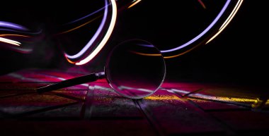 Karanlık arka planda, taş yüzeyinde büyüteç, aydınlık altında, gizemli dedektif konsepti