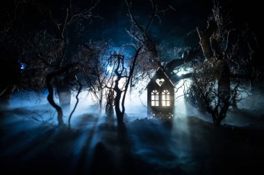 Karanlık ormanda ışıkla duran bir insan silueti. Korku Cadılar Bayramı konsepti. Karanlık ve ürkütücü bir köyde tuhaf bir siluet.