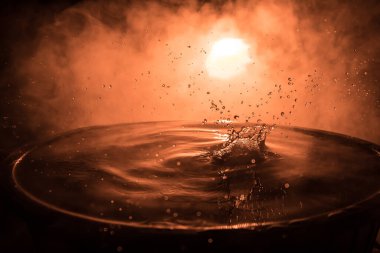 Karanlık sisli arka planda su sıçraması. Seçici odak.