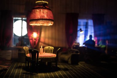 Romantik Ambiance: Geceleyin Gerçekçi Dollhouse Salonu, Zarif Mobilyalar, Pencereden Parlayan Yumuşak Pencere, Masa Üzerinde El Sanatı. Seçici odak