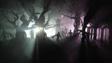 Karanlık ormanda ışık altında duran heykelciklerden oluşan bir siluet. Korku cadılar bayramı konsepti, karanlık ürkütücü köyde garip siluetler.