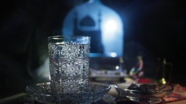 Arap çayı bardakta, doğu aperatifleriyle birlikte koyu arkaplanda, ışık ve dumanlı taş bir zemin üzerinde. Doğu çay konsepti