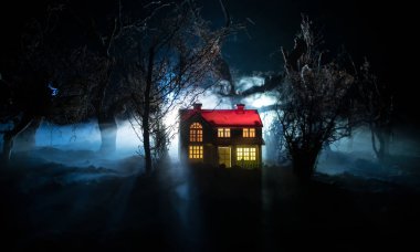 Karanlık ormanda ışıkla duran bir insan silueti. Korku Cadılar Bayramı konsepti. Karanlık ve ürkütücü bir köyde tuhaf bir siluet.