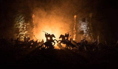 Süvari ve piyade ile ortaçağ savaş sahnesi. Siluetleri şekiller ayrı nesneler olarak mücadele koyu tonda sisli arka plan savaşçılar arasında. Gece sahne. Seçici odak