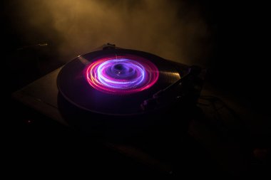 Müzik Dj konsepti. Yangın ve duman vinil kayıt üzerinde iz. Vinil disk yazma. Pikap vinil plak çalar koyu arka plan üzerinde. Seçici odak
