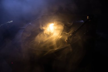 Müzik Dj konsepti. Yangın ve duman vinil kayıt üzerinde iz. Vinil disk yazma. Pikap vinil plak çalar koyu arka plan üzerinde. Seçici odak