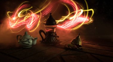 Arap çayı bardakta, doğu aperatifleriyle birlikte koyu arkaplanda, ışık ve dumanlı taş bir zemin üzerinde. Doğu çay konsepti. Seçici odak.