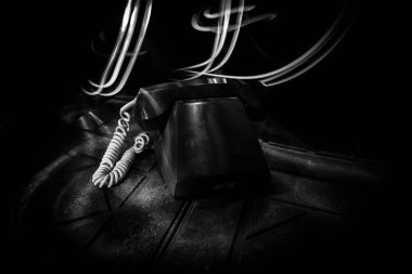 Eski ahşap kalas üzerinde numarası olmayan, sisli ve tonlu ışıkla sanat esintili eski bir telefon. Boşluk. Seçici odak