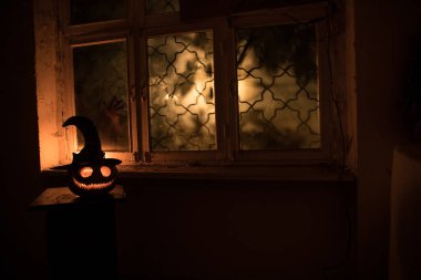 Geceleri mistik evdeki korkunç Cadılar Bayramı balkabağı ya da penceredeki cadılar bayramı balkabağı ve korku silueti. Seçici odak