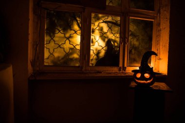 Geceleri mistik evdeki korkunç Cadılar Bayramı balkabağı ya da penceredeki cadılar bayramı balkabağı ve korku silueti. Seçici odak