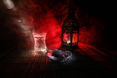 Ramazan orucu sırasında Suhoor veya iftar zamanı. Bir bardak su ve oruç tutmak için hurma. Kutlama kartı, Müslüman kutsal ayı için davetiye Ramazan Kareem. Seçici odak