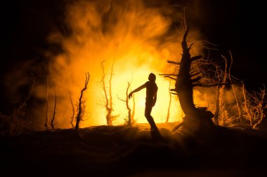 Karanlık ormanda duran bir insan silueti. Korku Cadılar Bayramı konsepti. Gecenin karanlığında ürkütücü bir ormanda tuhaf bir siluet.