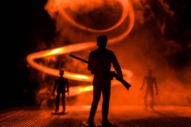 Bir av partisi sırasında tüfekli bir adamın silueti ava nişan alıyor. Renkli sisli arka planda minyatür siluet. Seçici odak