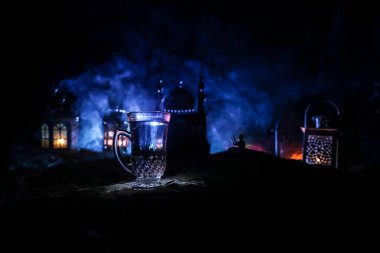 Ramazan orucu sırasında Suhoor veya iftar zamanı. Bir bardak su ve oruç tutmak için hurma. Kutlama kartı, Müslüman kutsal ayı için davetiye Ramazan Kareem. Seçici odak
