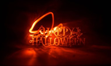 Cadılar Bayramı konsepti Cadılar Bayramı balkabağı kafası masada. Arka planda sis olan tonlu bir ışık. Seçici odaklanma. Uzun deklanşör.