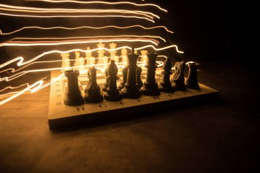 İş fikirleri ve rekabet Satranç tahtası oyun kavramı. Duman ve sis ile karanlık bir arka plan üzerinde Satranç rakamlar. Seçici odaklama