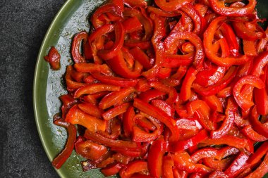 Izgara sebze. Koyu arka planda ızgara kırmızı biber şeritli tabak. Sağlıklı gıda konsepti.