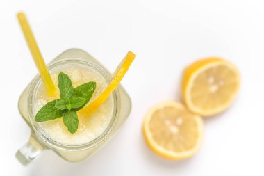 Ayrı bir içki. Bir bardak limonata ya da limon suyu ve beyaz arka planda kavanozda saman..