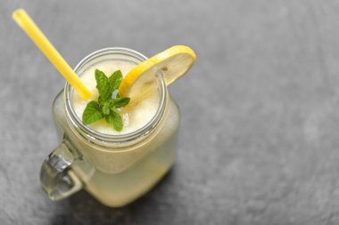 Saman ile taze yaz içeceği. Limonlu bir kavanoz limonata ve arka planda nane şekeri.