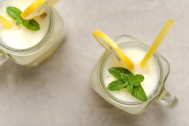 Kumsalda cam kavanozlarda iki limonata. Taze yaz içkileri, üst manzara..