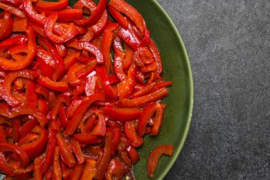 Izgara sebze. Koyu arka planda ızgara kırmızı biber şeritli tabak. Sağlıklı gıda konsepti.