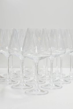 Barda bir sürü şarap kadehi var. Masada kristal gibi boş şarap kadehleri var. Alkol arka planı.