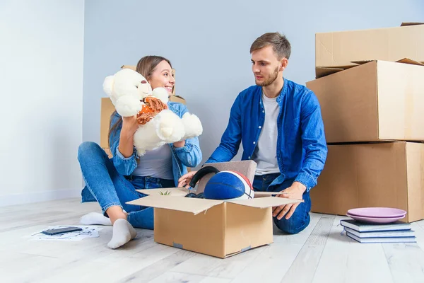 Young couple unpacking their things from boxes after moving into new house.