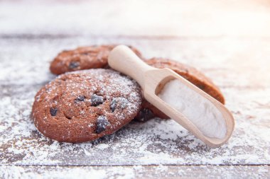 Ahşap zemin üzerine çikolata parçacıklı kurabiyeler serpiştirilmiş pudra şekerli. Taze kış pastası..