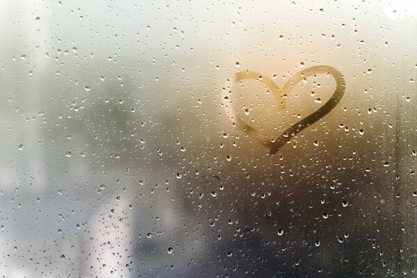 Rainy weather, the inscription heart on the sweaty glass.