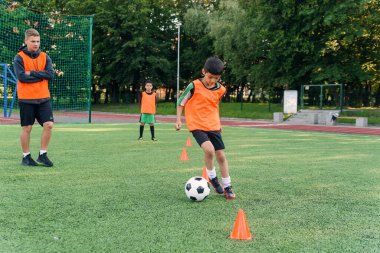 Futbolcu sahada topa vuruyor. Futbol oyuncuları antrenman yapıyor. Yeşil çimlerde topa vuran futbolcunun ayaklarını kapat..