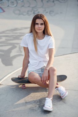 Beyaz eşofman altı ve kaykaylı kaykay parkında diz üstü çoraplı çekici bir kız. 80-90 'ların ruhu, Miami tarzı. Model.