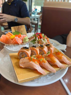 close up spicy salmon sushi and sashimi for lunch party