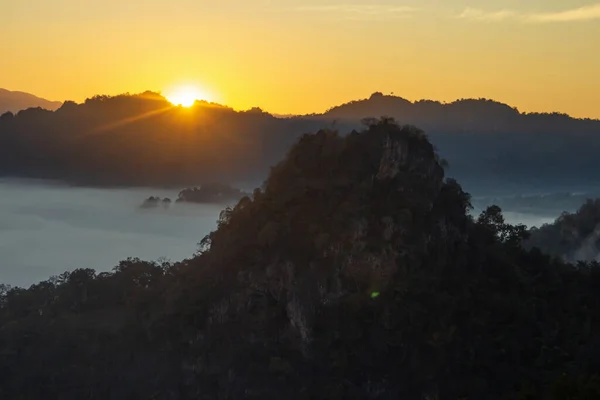 stock image Natural fog and mountains sunlight background blurring, misty waves warm colors and bright sun light. Christmas background sky sunny color orange light patterns, abstract flare evening on clouds blur.