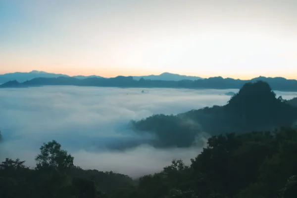 stock image Natural fog and mountains sunlight background blurring, misty waves warm colors and bright sun light. Christmas background sky sunny color orange light patterns, abstract flare evening on clouds blur.