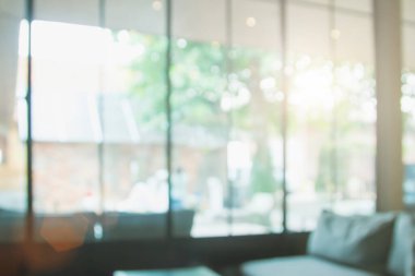 Arka plan için soyut bulanık kahve dükkanı ya da kafe. Bulanık restoran iç afişi. Kafe Bokeh 'le bulanıklaşıyor. Bulanık pencereler yeşil bahçe arka planı. Bulanık insanlar olmayan bir iş yeri. Masalar, iş yerindeki bina bulanıklığı.