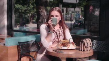 Yetişkin bir kız kahve içer ve selfie çeker.