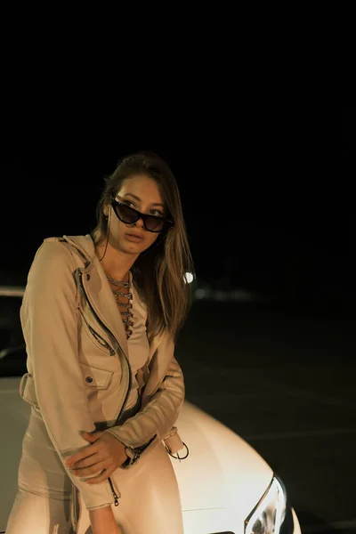 Gece Beyaz Bir Arabanın Önünde Poz Veren Bir Kız — Stok fotoğraf