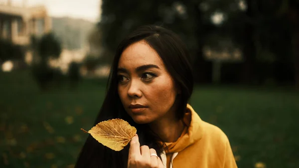 Kız Elinde Bir Sonbahar Yaprağı Tutuyor Sağa Bakıyor — Stok fotoğraf