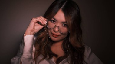 Kız başını öne eğdi, gözlüğünü tuttu ve ona baktı.