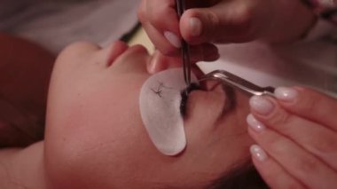 Kozmetik uzmanı takma kirpikleri kontrol eder ve gereksiz yere temizler.