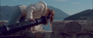 The girl inspects the ancient cannon in the fortress