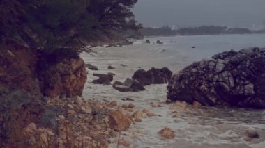 Storm wave moves towards the coast and breaks on the rocks