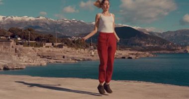 # Genç kız ipin üzerinde atlarken, orada dikiliyor #