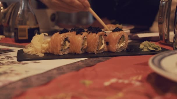 Een Meisje Neemt Sushi Met Stokjes Dompelt Het Sojasaus — Stockvideo